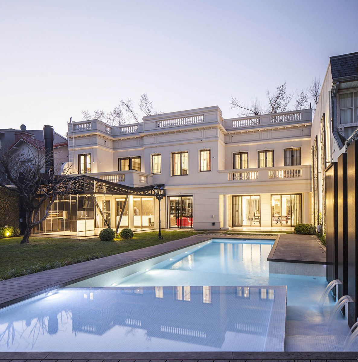 En la casa urbana todo el jardín posterior es una gratificación a cielo abierto. La larga piscina con zona playa, deck y fuentes de agua, termina en un gran solarium. La superficie de la casa se extiende en una estructura vidriada donde se ubica el espectacular quincho (Casa Pemorán, Vanguarda Arquitectos)